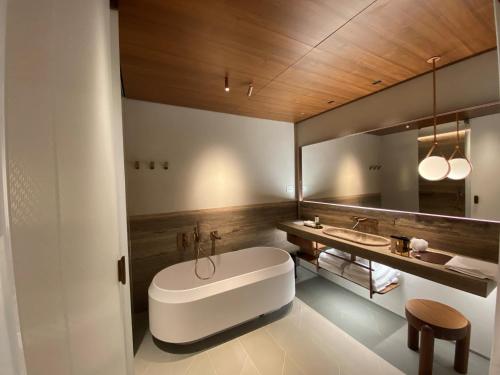 a bathroom with a large white tub and a sink at Il Sereno Lago di Como in Torno