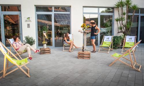 a group of people sitting in lawn chairs outside a store at Wein & Bett Weihbrecht in Bretzfeld