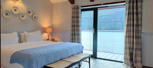 a bedroom with a bed and a large window at Black Sheep Hotels Cabins in Spean Bridge
