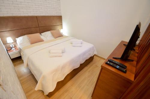 a bedroom with a large bed with a flat screen tv at Djardin in Kotor