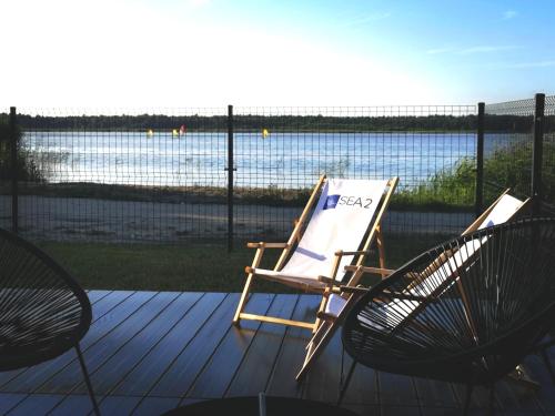 a rocking chair on a deck with a view of the water at Sea2 in Nowęcin