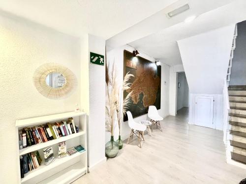 uma sala de estar com uma escadaria e paredes brancas em Hostal Vista Alegre em Port d'Alcudia