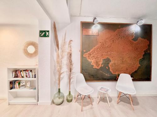 a room with two chairs and a map on the wall at Hostal Vista Alegre in Port d'Alcudia