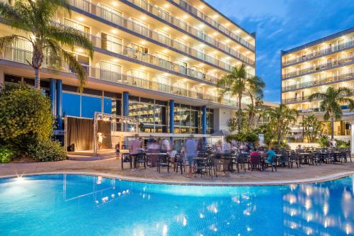 un hotel con piscina frente a un edificio en Sol Costa Daurada, en Salou