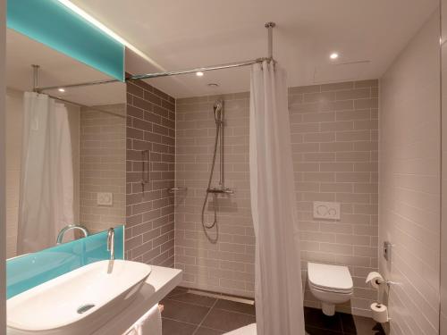 a bathroom with a shower and a sink and a toilet at Holiday Inn Express - Offenbach by IHG in Offenbach