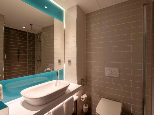 a bathroom with a sink and a toilet and a tub at Holiday Inn Express - Offenbach by IHG in Offenbach