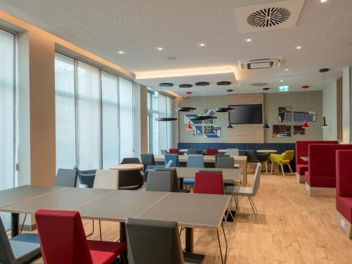 a conference room with tables and chairs and windows at Holiday Inn Express - Offenbach by IHG in Offenbach