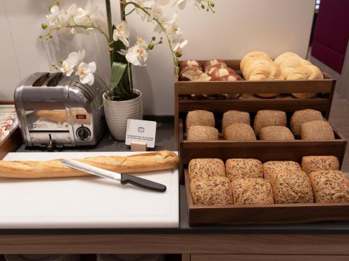 a bakery with bread and pastries on a counter at Holiday Inn Express - Offenbach by IHG in Offenbach