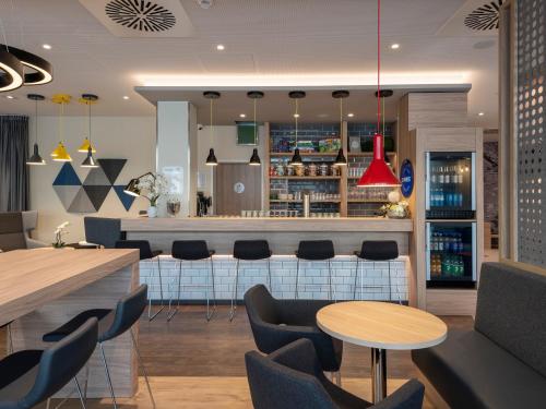 a restaurant with tables and chairs and a bar at Holiday Inn Express - Offenbach by IHG in Offenbach