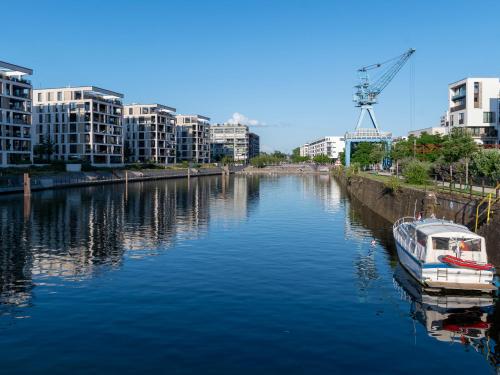 a boat is docked in a river with buildings at Holiday Inn Express - Offenbach by IHG in Offenbach