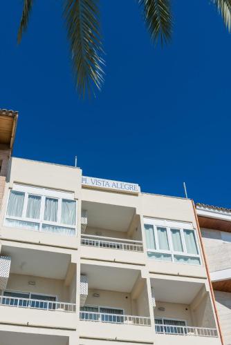 um edifício branco com um cartaz em Hostal Vista Alegre em Port d'Alcudia