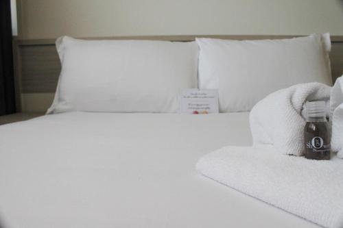 a white bed with towels and a bottle on it at Best Quality Hotel Politecnico in Turin
