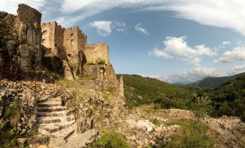 a castle on top of a mountain with stairs at Camping du Lac in Marcillac-la-Croisille