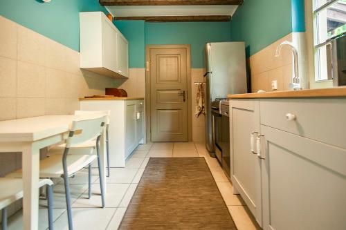a kitchen with a table and a refrigerator at Domek pod Grabami in Gdańsk