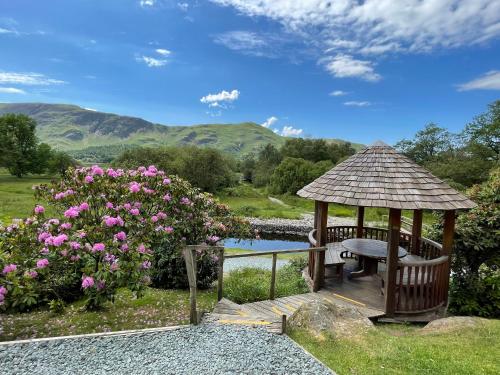 a gazebo with a bench next to a pond at The Mary Mount Hotel in Keswick