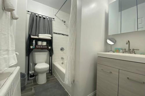 La salle de bains est pourvue de toilettes, d'un lavabo et d'une baignoire. dans l'établissement Luxury Meets Convenience! Near NYC & EWR Airport, à Lodi