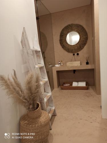 ein Badezimmer mit einem Spiegel und einer Vase mit Federn in der Unterkunft Casa Rural Pucariças - Country & Nature in Proença-a-Nova