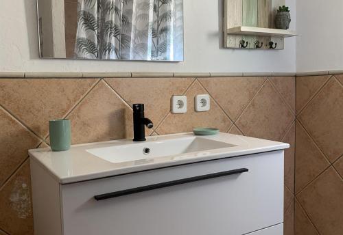ein Badezimmer mit einem weißen Waschbecken und einem Spiegel in der Unterkunft Casa Don Fernando in Moraira