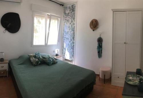 ein Schlafzimmer mit einem grünen Bett und einem Fenster in der Unterkunft Casa Don Fernando in Moraira