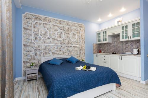a bedroom with a blue bed and a kitchen at EtazhiDaily in Centre in Yekaterinburg