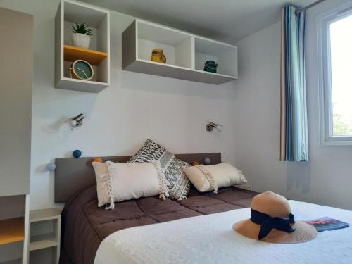 um quarto com uma cama com um chapéu em Camping de Saulieu em Saulieu