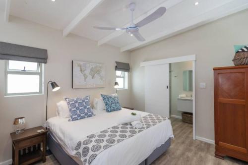 a bedroom with a bed and a ceiling fan at Ebb in Knysna
