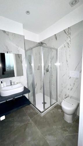 a bathroom with a shower and a toilet and a sink at Hotel Porto Di Roma in Civitavecchia