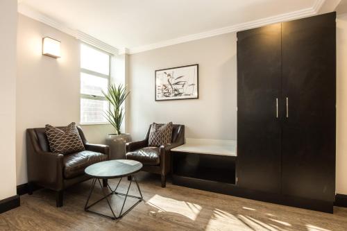 a waiting room with two chairs and a cabinet at Belaire Suites Hotel in Durban