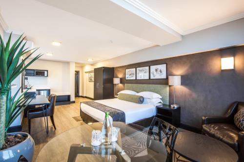 a hotel room with a bed and a table at Belaire Suites Hotel in Durban