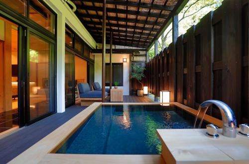 a swimming pool in a house with a bathroom at Sakahijiri gyokushoen in Izu