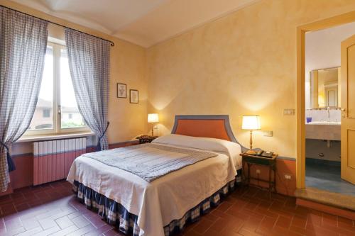 a bedroom with a bed and two windows at Marchesi Incisa Winery Lodge in Rocchetta Tanaro