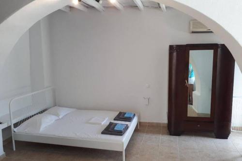 a bedroom with a white bed and a mirror at Antigonis traditional house in lefkes village in Lefkes
