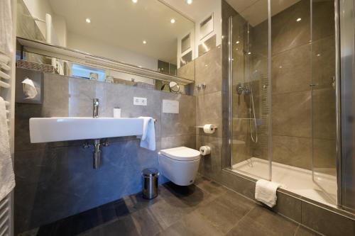 a bathroom with a toilet and a sink and a shower at Hotel Bayerischer Hof in Bayreuth