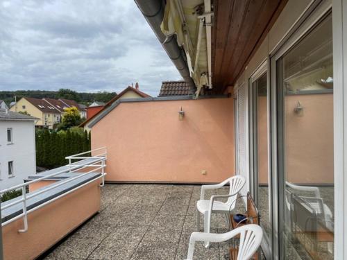 a balcony with two white chairs on a building at Sonnenschein in Idstein