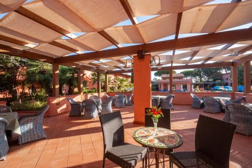 an outdoor patio with chairs and a table and a wooden pergola at Hotel Residence Villa San Giovanni in Portoferraio