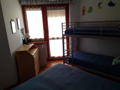 sypialnia z dwoma łóżkami piętrowymi i oknem w obiekcie Appartamento del sole w mieście Bardonecchia