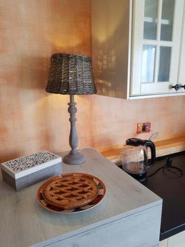 a lamp on a counter with a pie on a plate at Dimora in Francigena in San Quirico dʼOrcia