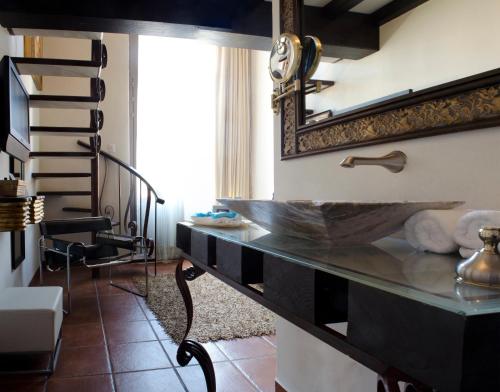 a bathroom with a sink and a mirror at Hotel Herencia By Hosting House in Morelia