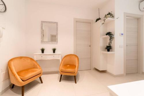 Zimmer mit 2 Stühlen, einem Schreibtisch und einem Spiegel in der Unterkunft NUOVO LOFT al MARE con PARCHEGGIO GRATUITO in Misano Adriatico