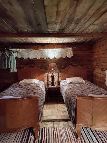 a bedroom with two beds in a log cabin at Muhu Tõnise Talu in Liiva