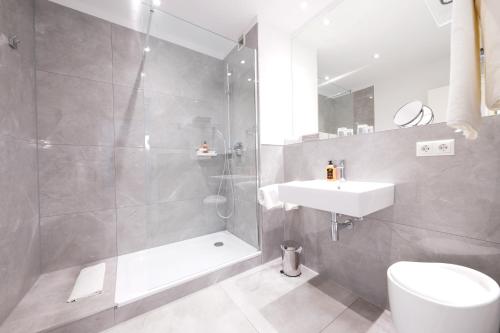 a bathroom with a shower and a sink and a toilet at Hotel Bayerischer Hof in Bayreuth