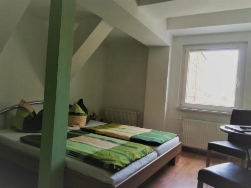 a bedroom with a bed and a window at Pension & Ferienwohnung Zum Schmuckgiebel in Tangermünde