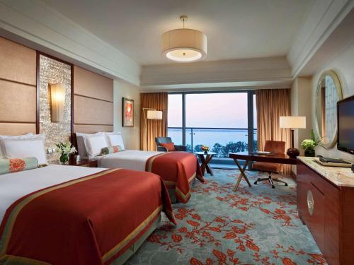 a hotel room with two beds and a television at Fairmont Yangcheng Lake in Kunshan