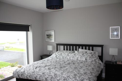 a bedroom with a bed and a large window at Sea Vista - Rathmullan in Rathmullan