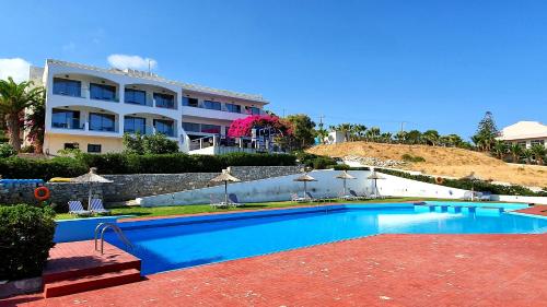 una piscina di fronte a un grande edificio di Stella Beach Hotel a Panormos