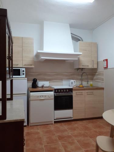 a kitchen with white appliances and wooden cabinets at Casa Encantada - Golegã in Golegã
