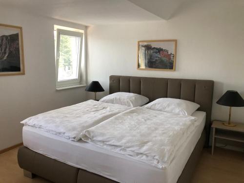 a bedroom with a large white bed with two lamps at Luise in Obernkirchen