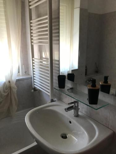 un lavandino bianco in un bagno con finestra di L'Alloggio Perfetto a Putignano