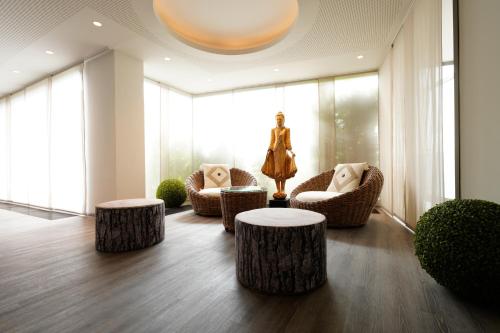 a room with two tables and two chairs and a statue at Hotel Bayerischer Hof in Bayreuth