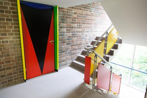 a colorful door in a brick wall with stairs at Rotel Inn in Passau